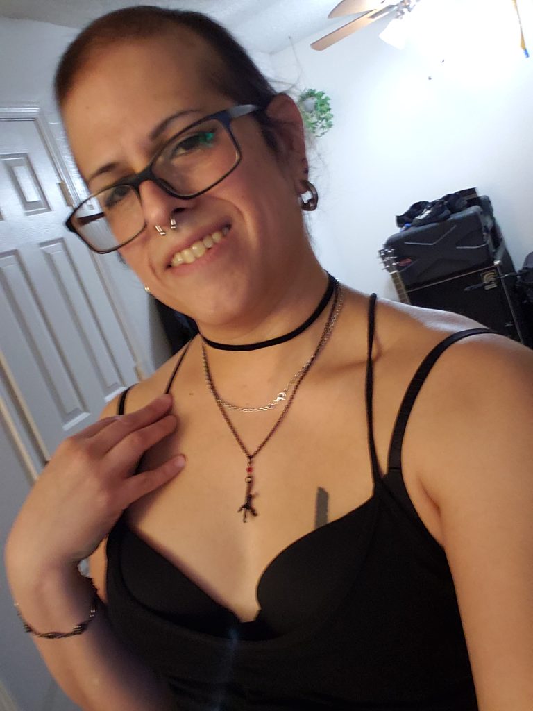 Vivi Dusk standing in a beautiful, tiny black dress before leaving for a live show.